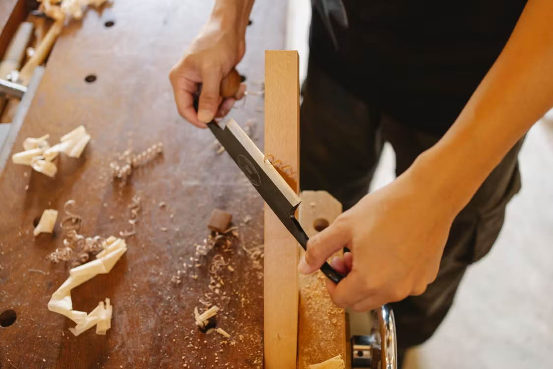Carpenter shaping a wood joint by hand